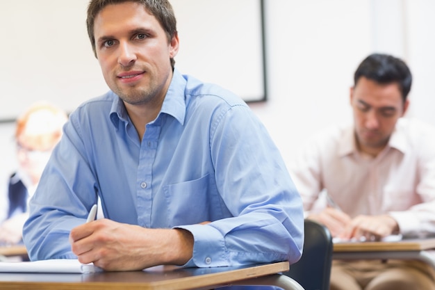 Foto studenti maturi che prendono le note in aula