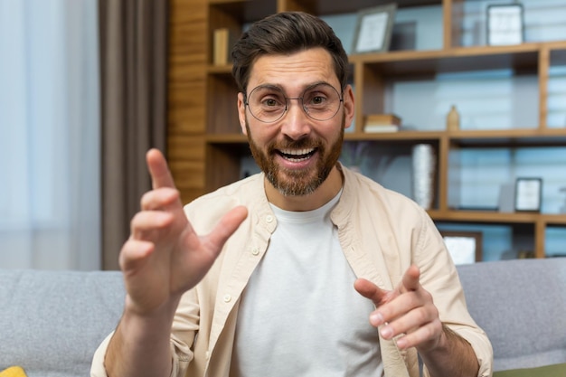 Mature teacher teaching online remotely man with glasses and beard looking at web camera and smiling