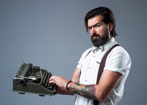 mature typist use vintage typewriter. masculinity and charisma. formal party dress code. old fashioned bearded hipster. journalistic concept. brutal handsome man with moustache. copy space.