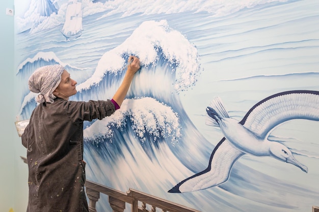 사진 성숙 한 여성 예술가 는 해양 주제 로 벽화 를 그린다
