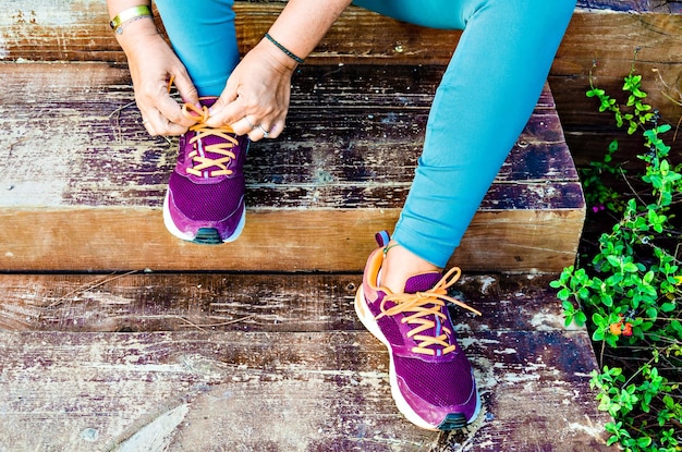 Photo mature woman athlete preparing to run in the park.