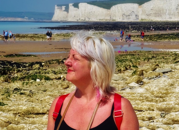 Foto donna matura sulla spiaggia in una giornata di sole