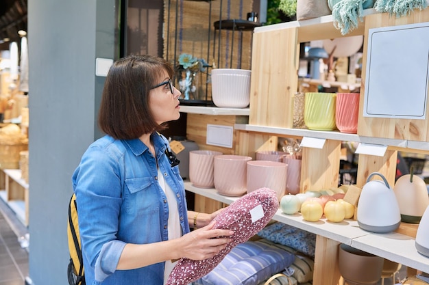 写真 現代のインテリア ストアでソファ クッションを選ぶ成熟した女性