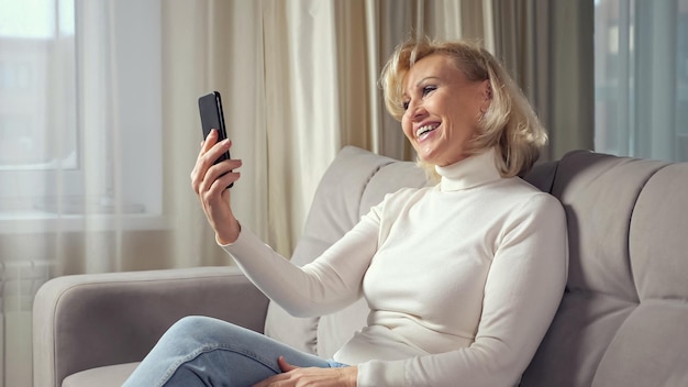 Mature woman communicates via videocall using smartphone