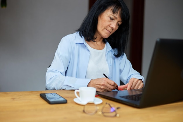 Mature woman designer drawing with graphics tablet and stylus