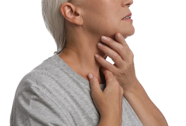 Mature woman doing thyroid self examination on white background closeup