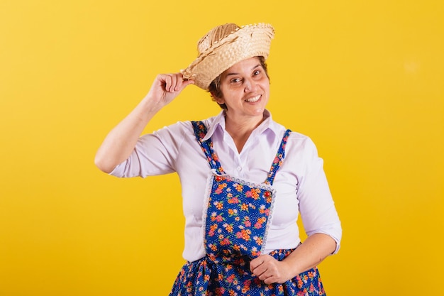 Mature woman dressed in typical Festa Junina clothes Holding straw hat