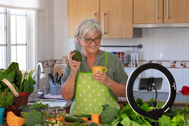 Mature woman following online cooking lesson blogger video vegetarian vegan diet