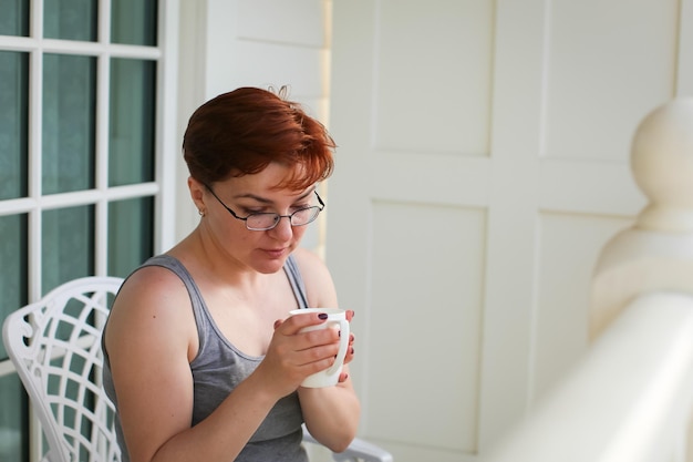 Photo mature woman holding coffee cup on balcony