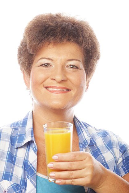 Foto donna matura con in mano un bicchiere di succo d'arancia