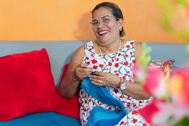 Mature woman knitting in living room