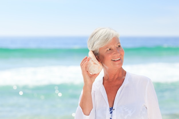 Mature woman listening to her shell