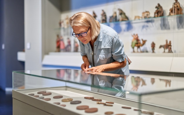 Photo mature woman looking at exhibit.