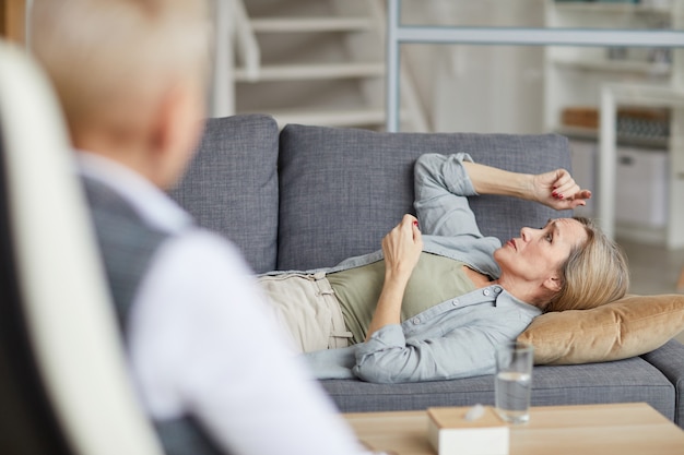 Foto donna matura luying sul divano in sessione di terapia