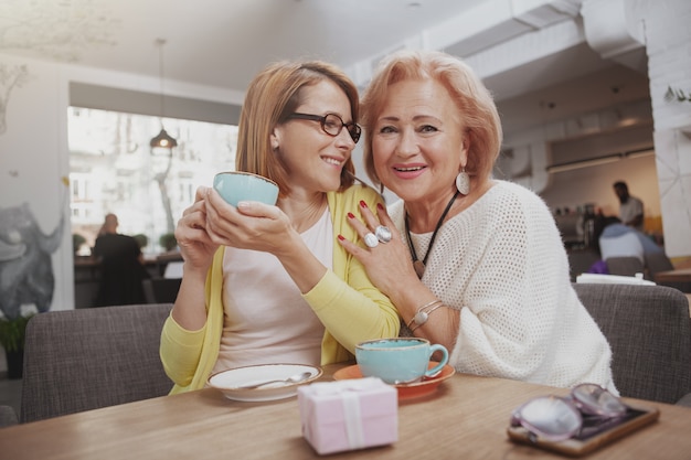 Mature woman meeting her senior mother at the coffee shop