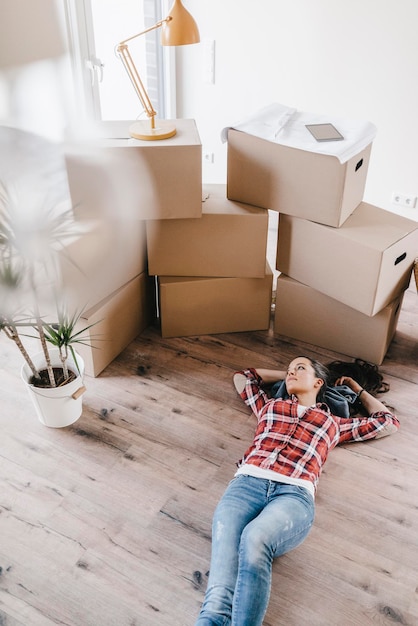 Mature woman moving house, lying on floor, thinking