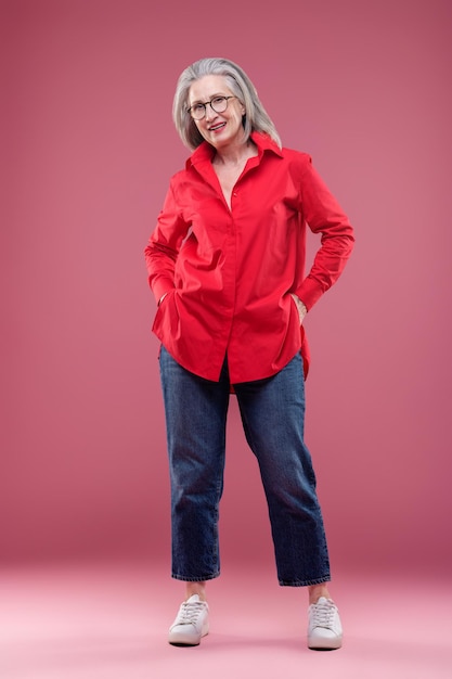 Photo mature woman in red shirt looking contented