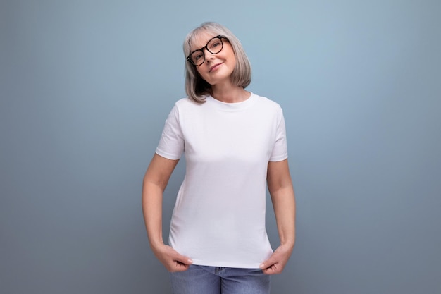 A mature woman of retirement age is in menopause in a white tank top on a studio background