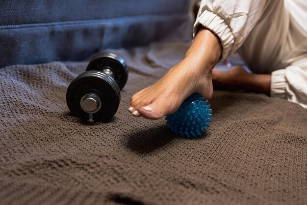 Mature woman's foot with relaxation ball at home