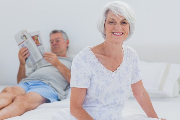 Mature woman sitting on bed