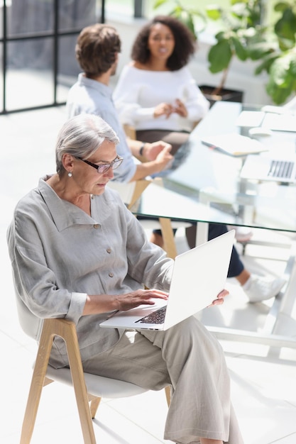 mature woman sitting and looking at laptop