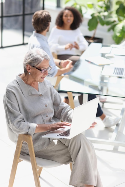 Mature woman sitting and looking at laptop