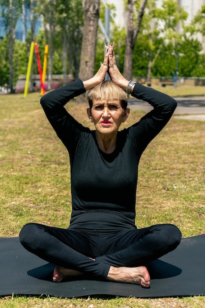 Mature woman sitting practicing yoga seeking greater concentration and directing her energy. Concept concentration, healthy life.