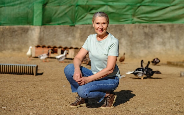 Mature woman on a small chicken and duck farm