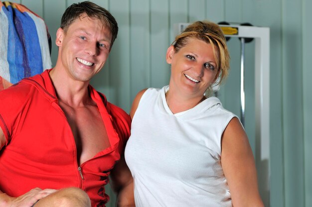 Mature woman smiling with fitness trainer in gym