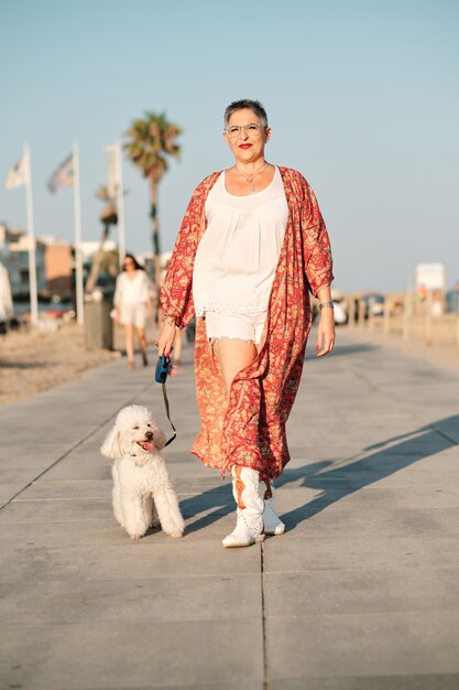 夏の日に犬と散歩をしている成熟した女性