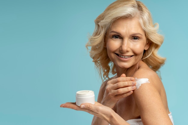 Mature woman touching soft fresh skin applying a moisturizing cream with skin lifting uplift effect