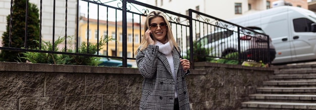 Mature woman walking around the city talking on a mobile phone freelance work concept