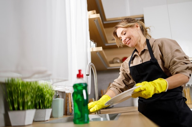 Mature woman washing dishes in a modern kitchen