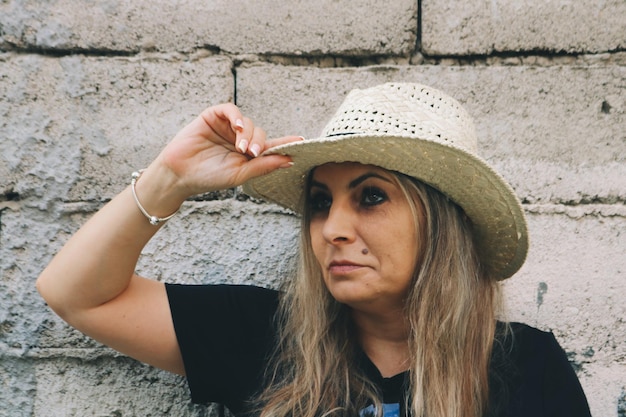 Foto donna matura che indossa un cappello contro il muro