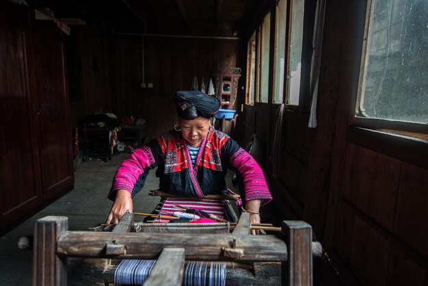 Фото Зрелая женщина ткает в мастерской