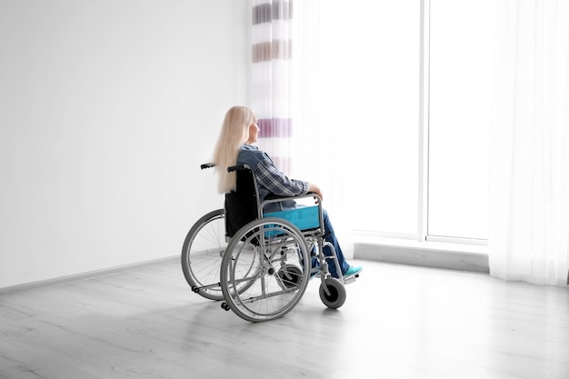 Mature woman in wheelchair indoors