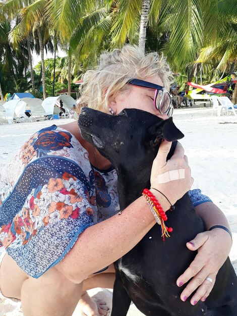 Foto donna matura con il cane in spiaggia