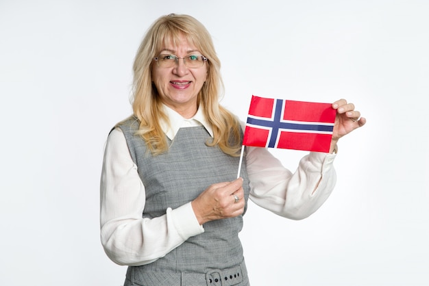 Mature woman with flag of Norway on bright background.