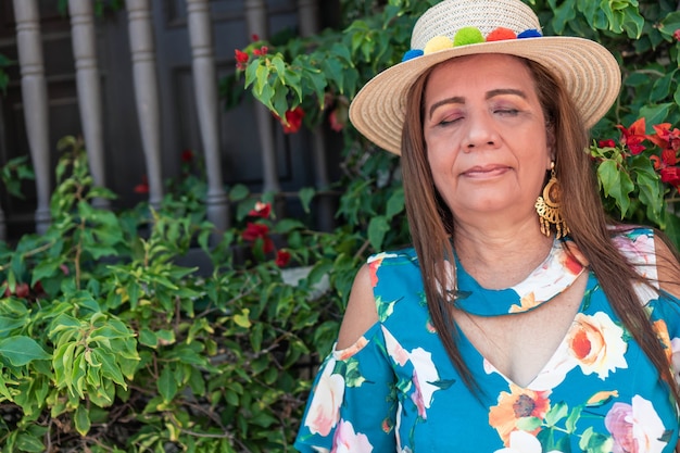 Mature woman with her eyes closed while taking a moment to herself.