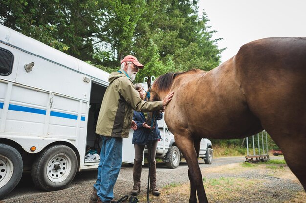 Foto donna matura con un cavallo vista attraverso l'ingresso