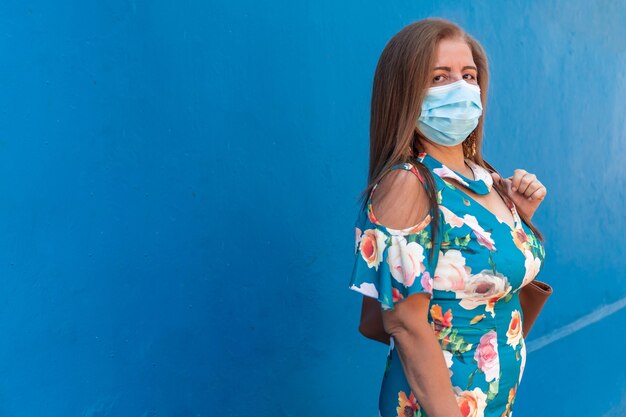 Mature woman with protective mask walking down the street