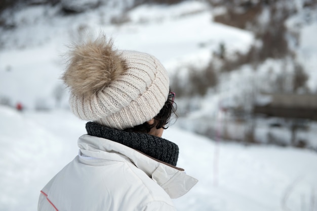 Donna matura con la protezione di inverno nella montagna