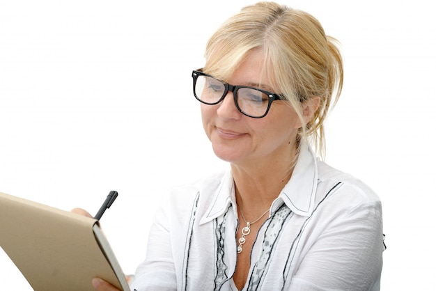 Mature woman writing on a notebook