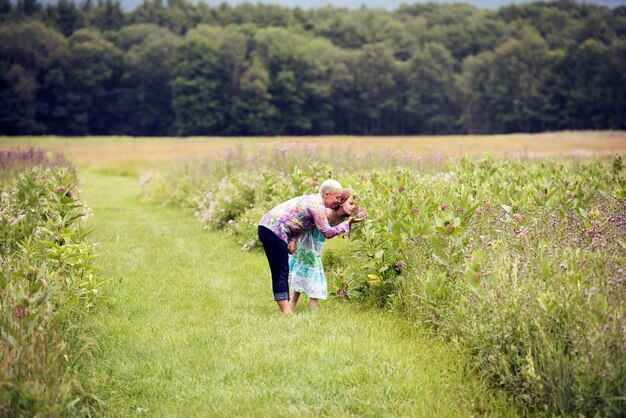 Photo a mature woman and a young girl in a wildflower meadow