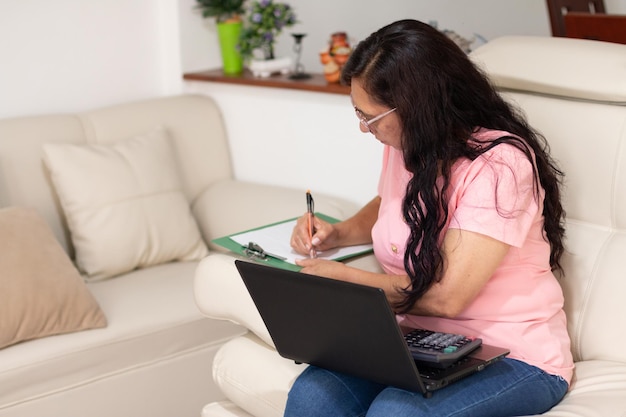 Mature working woman calculating her personal and professional finances