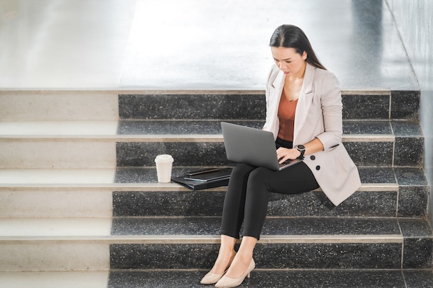 Matured businesswoman prepares report on laptop outside meeting before business meeting