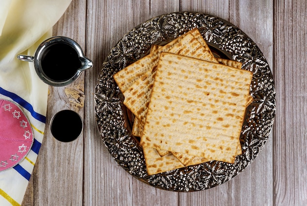 Matza, wijn, tallit en kippa op houten