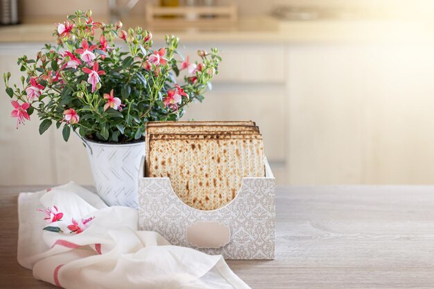 Matzah in een speciale doos met een inscriptie matze fuchsia bloem op de keukentafel Pesach achtergrond