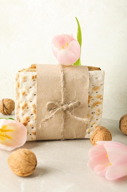 Matzo nuts and flowers on light background