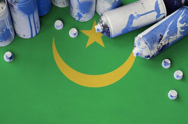 Mauritania flag and few used aerosol spray cans for graffiti painting Street art culture concept